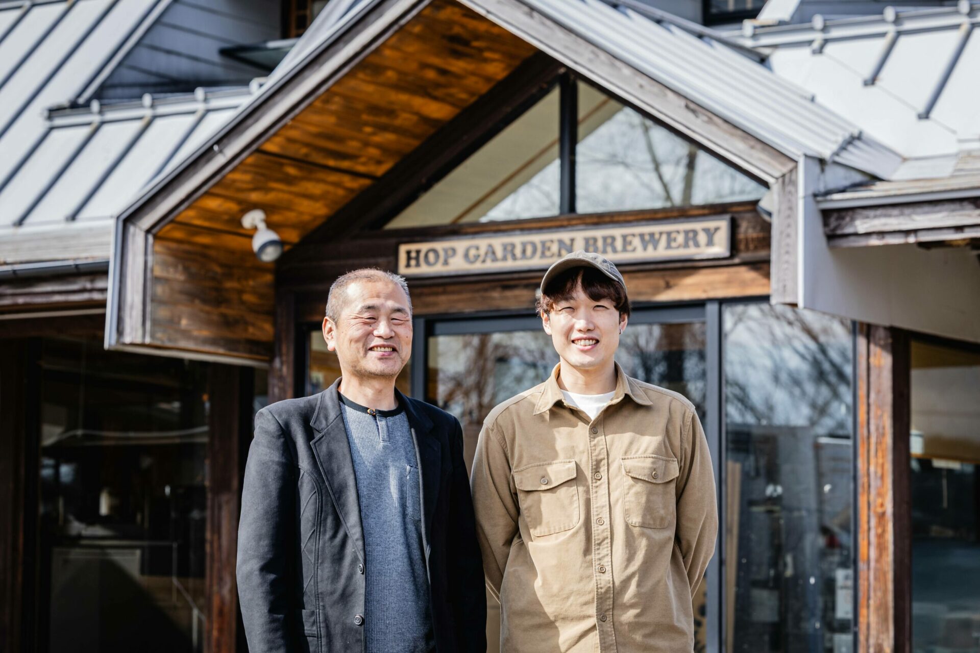 ブルワリーの前に立つ二人の男性