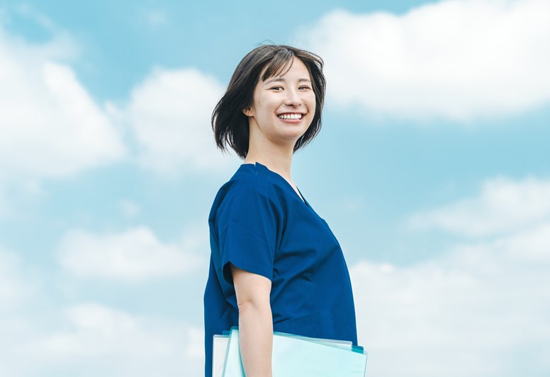 青空の下で微笑む医療スタッフ