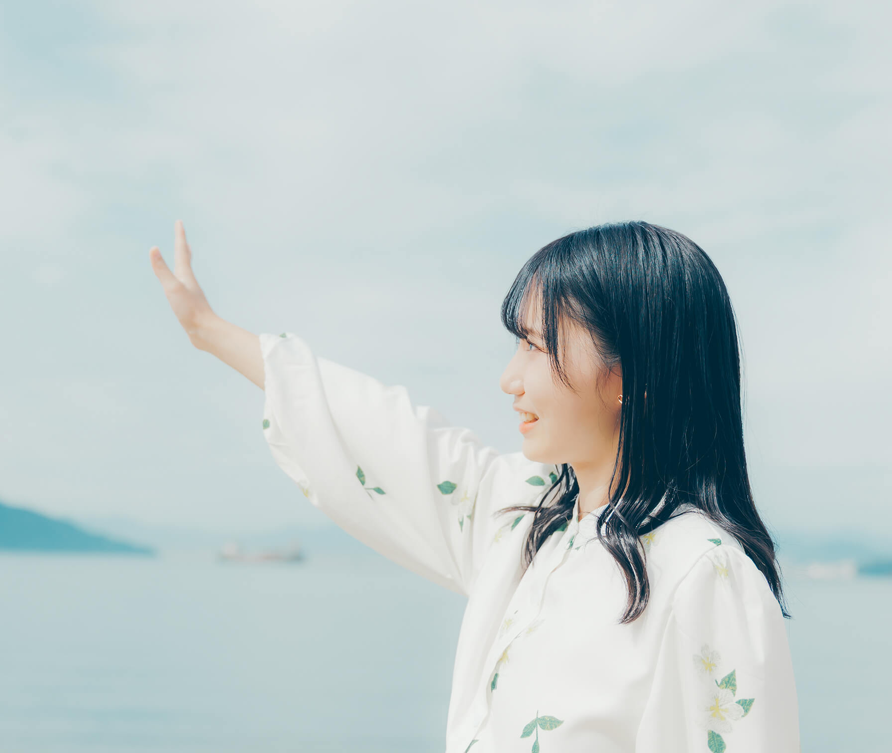 海辺で手を伸ばす女性